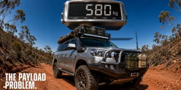 Fisheye outback track scene with a loaded 4WD under a giant floating scale reading 580 kg