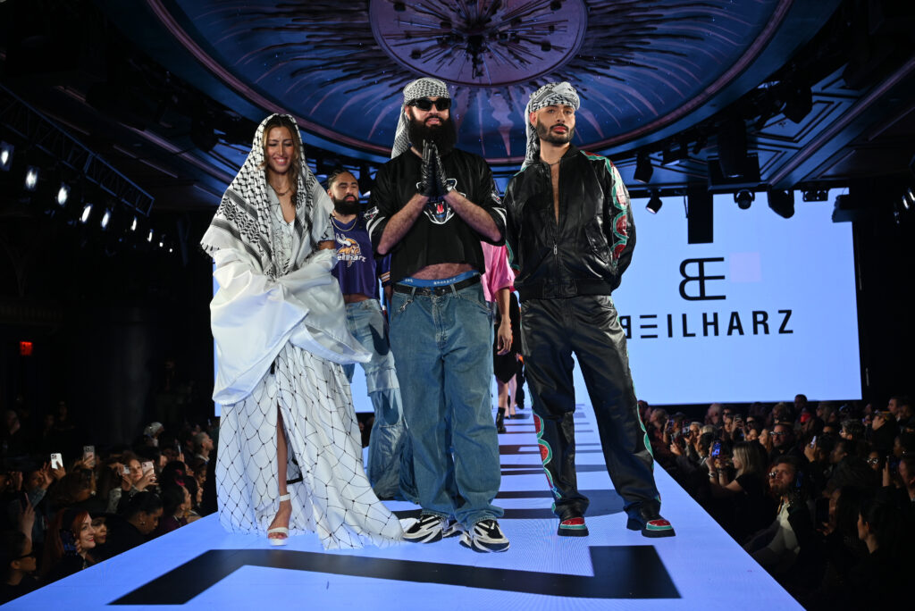 Beilharz finale walk, designers in keffiyehs leading models, brand logo on screen