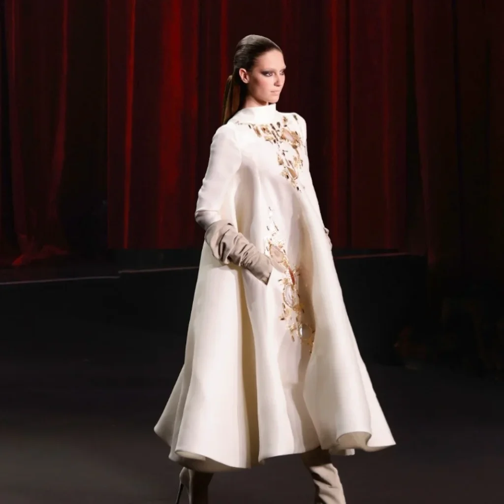 High-neck white couture coat with gold embellishment