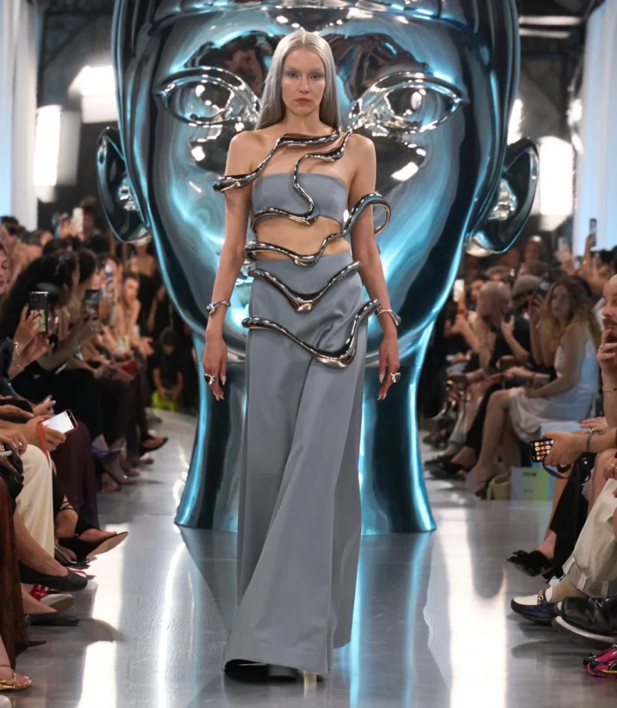 Liquid silver metal coiling across a grey-blue bandeau