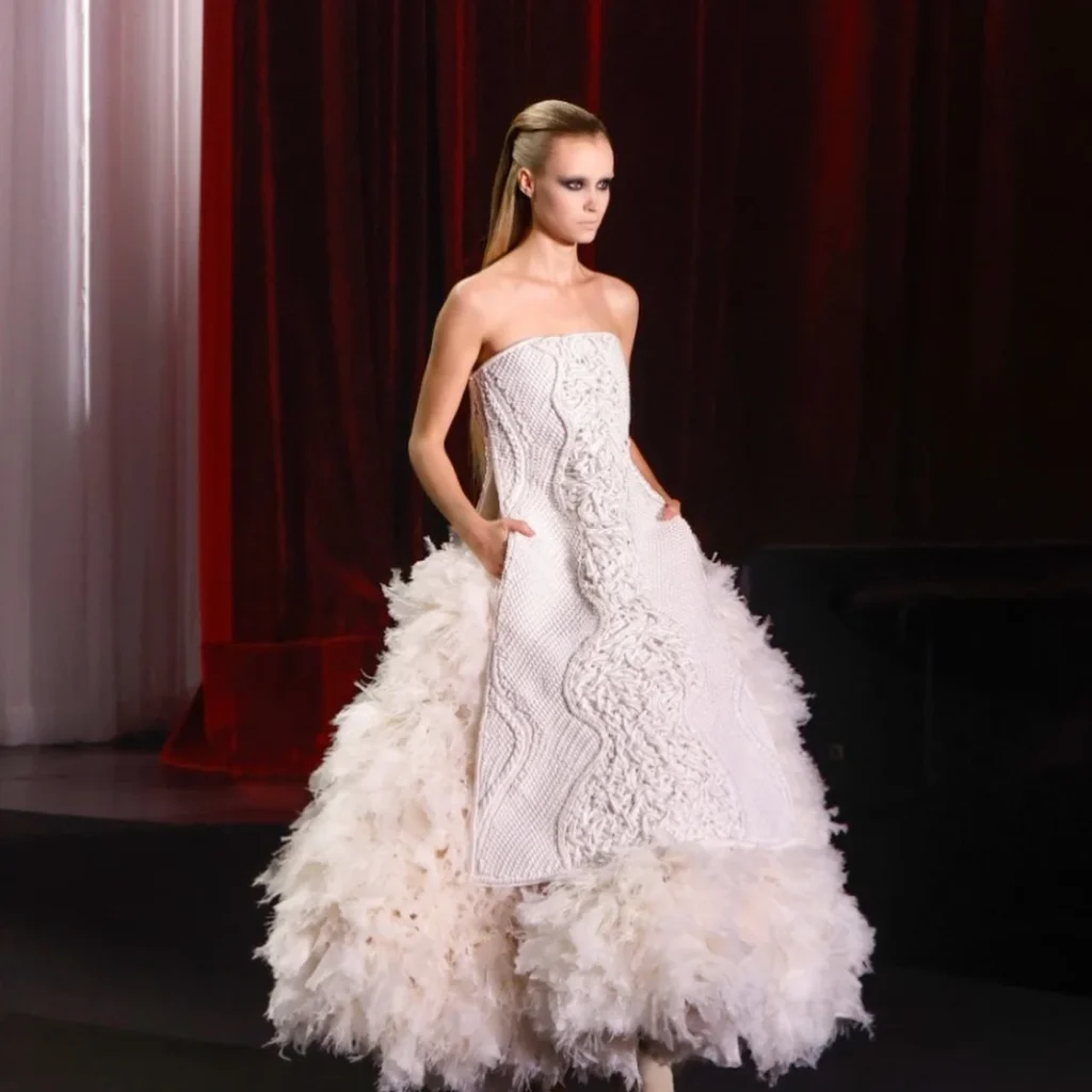 Strapless white macramé corset gown with ostrich feather skirt