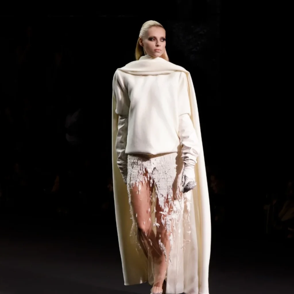 White knit and cape look over torn tulle feather skirt