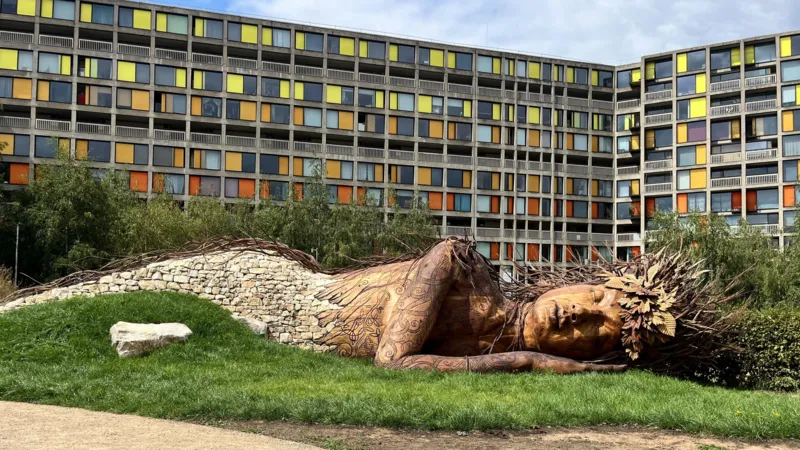Full view of the carved Gaia figure with willow hair and dry-stone wall at Park Hill