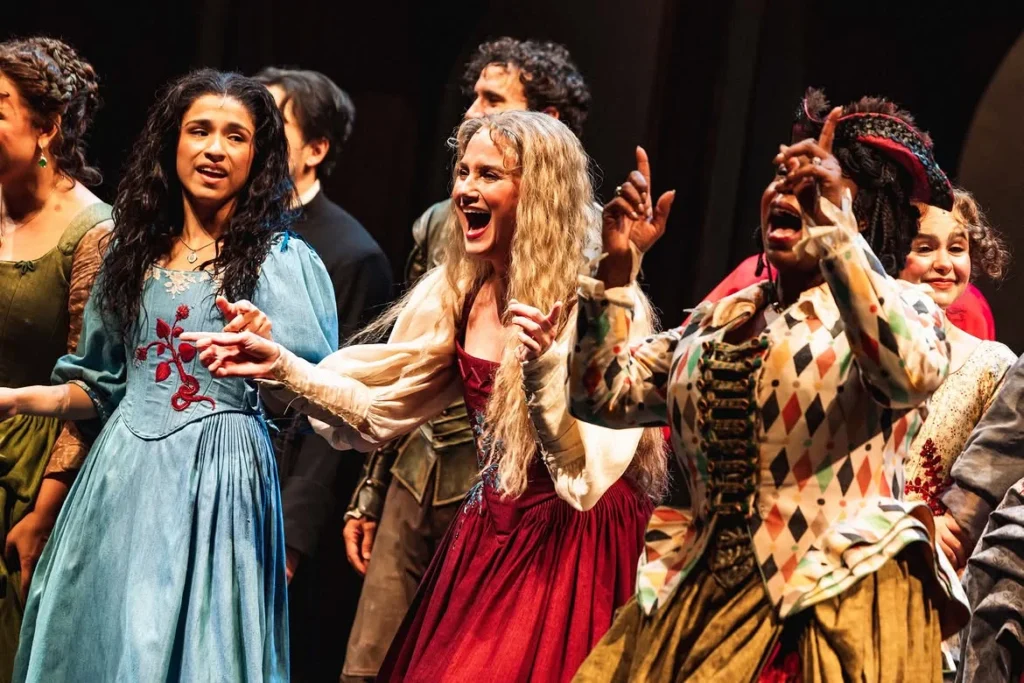 Nettles mid-celebration between castmates at the opening