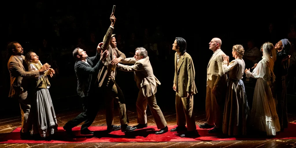 the company mid-struggle as the pistol is raised overhead, the play's contract with it's opening image coming due